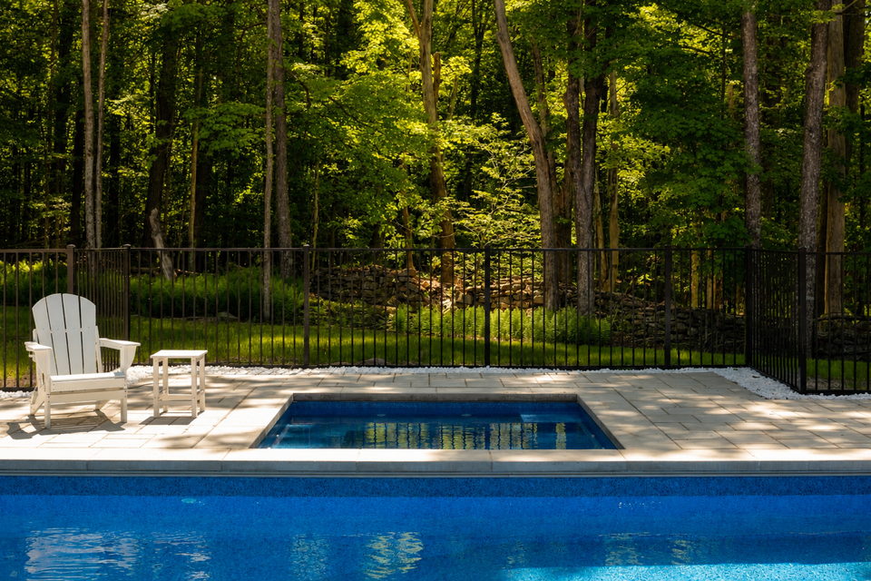Heated gunite pool with a concrete surround at the forest edge