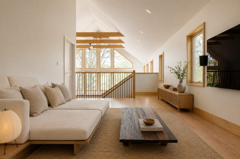 Bedroom under a cathedral ceiling facing the treeline